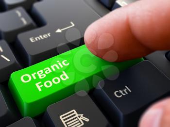 Organic Food Button. Male Finger Clicks on Green Button on Black Keyboard. Closeup View. Blurred Background.