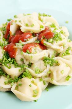 Boiled dumplings with onion and tomato sauce