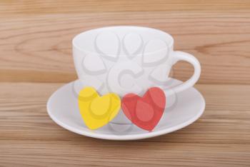 Coffee cup and hearts on a wooden background.
