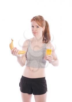 Athletic girl with a banana and juice in hand on white background.