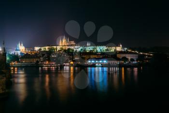 Night view of Prague cityscape, Czech Republic. Castle, St. Vitus Cathedral. Panorama of Lesser Town, Reflection in Vltava River