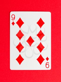 Old playing card (nine) isolated on a red background