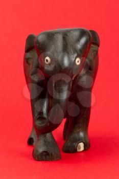 Very old ivory statue of an elephant isolated on a red beckground