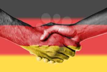 Man and woman shaking hands, wrapped in flag pattern, Germany
