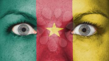 Close up of eyes. Painted face with flag of Cameroon