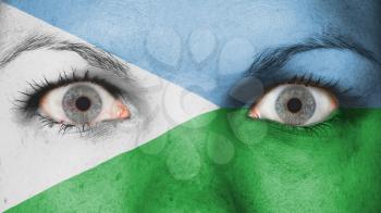 Close up of eyes. Painted face with flag of Djibouti