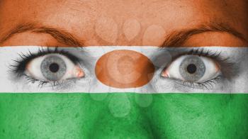 Close up of eyes. Painted face with flag of Niger
