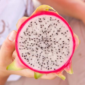 Woman holding a freshly cut dragon fruit