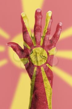 Hand of an old woman wrapped in flag of Macedonia