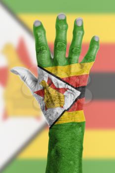 Hand of an old woman wrapped in flag of Zimbabwe