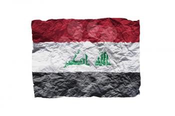Close up of a curled paper on white background, print of the flag of Iraq