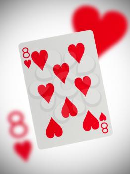 Playing card with a blurry background, eight of hearts