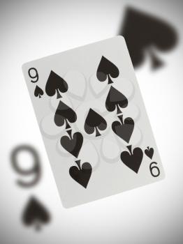 Playing card with a blurry background, nine of spades