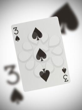 Playing card with a blurry background, three of spades