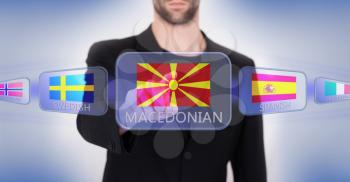 Hand pushing on a touch screen interface, choosing language or country, Macedonia