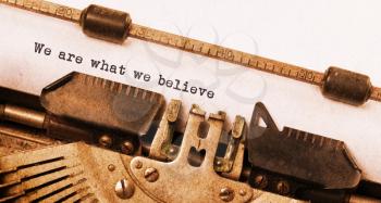 Vintage typewriter, old rusty, warm yellow filter - We are what we believe