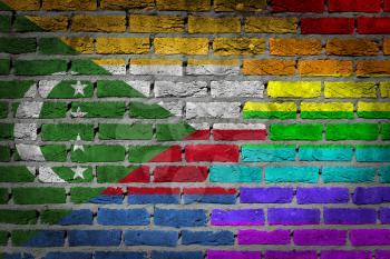 Dark brick wall texture - coutry flag and rainbow flag painted on wall - Comoros