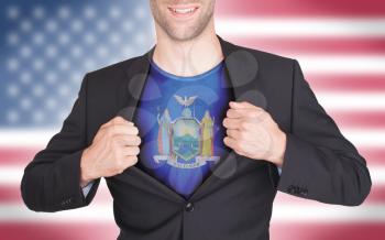 Businessman opening suit to reveal shirt with state flag (USA), New York