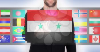 Hand pushing on a touch screen interface, choosing language or country, Syria