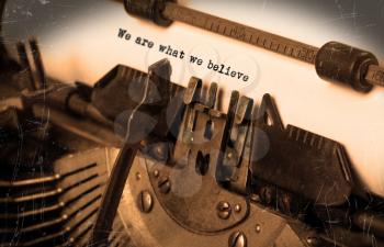 Close-up of an old typewriter with paper, selective focus, we are what we believe