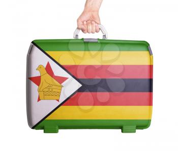 Used plastic suitcase with stains and scratches, printed with flag, Zimbabwe