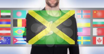 Hand pushing on a touch screen interface, choosing language or country, Jamaica