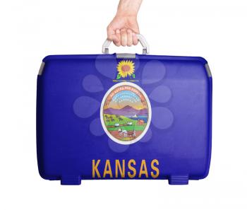 Used plastic suitcase with stains and scratches, printed with flag, Kansas