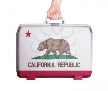 Used plastic suitcase with stains and scratches, printed with flag, Calofornia