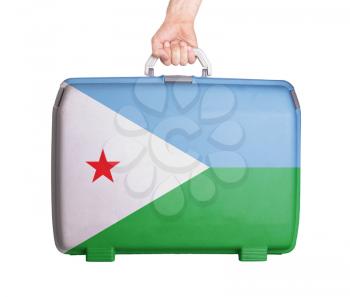 Used plastic suitcase with stains and scratches, printed with flag, Djibouti