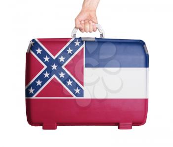 Used plastic suitcase with stains and scratches, printed with flag, Mississippi
