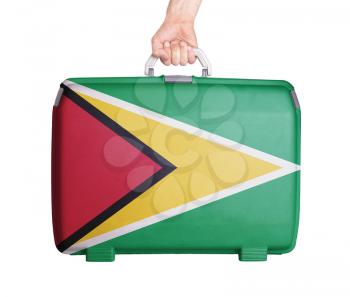 Used plastic suitcase with stains and scratches, printed with flag, Guyana
