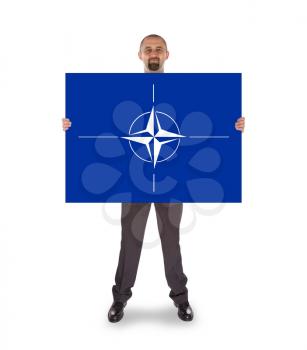 Businessman holding a big card, NATO symbol, isolated on white