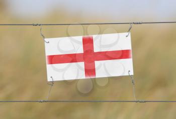 Border fence - Old plastic sign with a flag - England