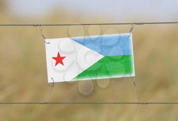 Border fence - Old plastic sign with a flag - Djibouti