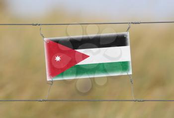 Border fence - Old plastic sign with a flag - Jordan