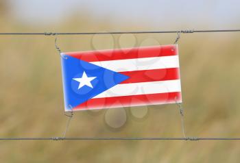 Border fence - Old plastic sign with a flag - Puerto Rico