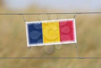 Border fence - Old plastic sign with a flag - Romania