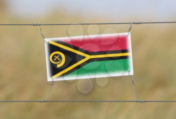 Border fence - Old plastic sign with a flag - Vanuatu