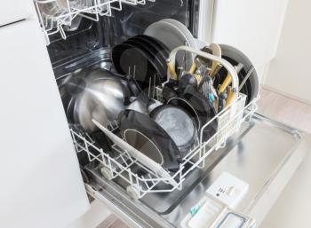Open dishwasher with clean plates, cups and dishes - Selective focus