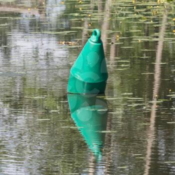 Green buoy in a large pond - Selective focus