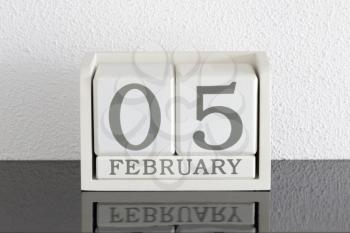 White block calendar present date 5 and month February on white wall background