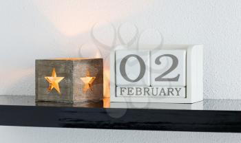 White block calendar present date 3 and month February on white wall background