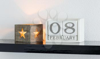 White block calendar present date 8 and month February on white wall background