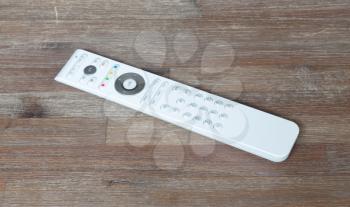 Single white remote on a wooden table