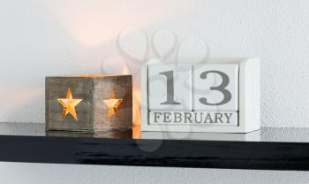 White block calendar present date 13 and month February on white wall background