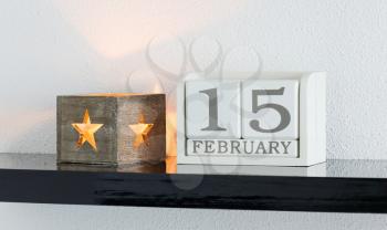 White block calendar present date 15 and month February on white wall background
