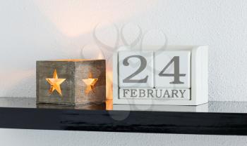White block calendar present date 24 and month February on white wall background