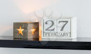 White block calendar present date 27 and month February on white wall background