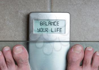 Closeup of man's feet on weight scale - Balance your life