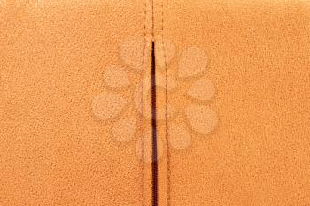 Background from brown suede close up, zipper in the middle, full frame